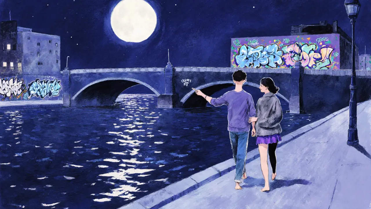 A couple walking barefoot along the Spree River at night, admiring graffiti murals under moonlight.