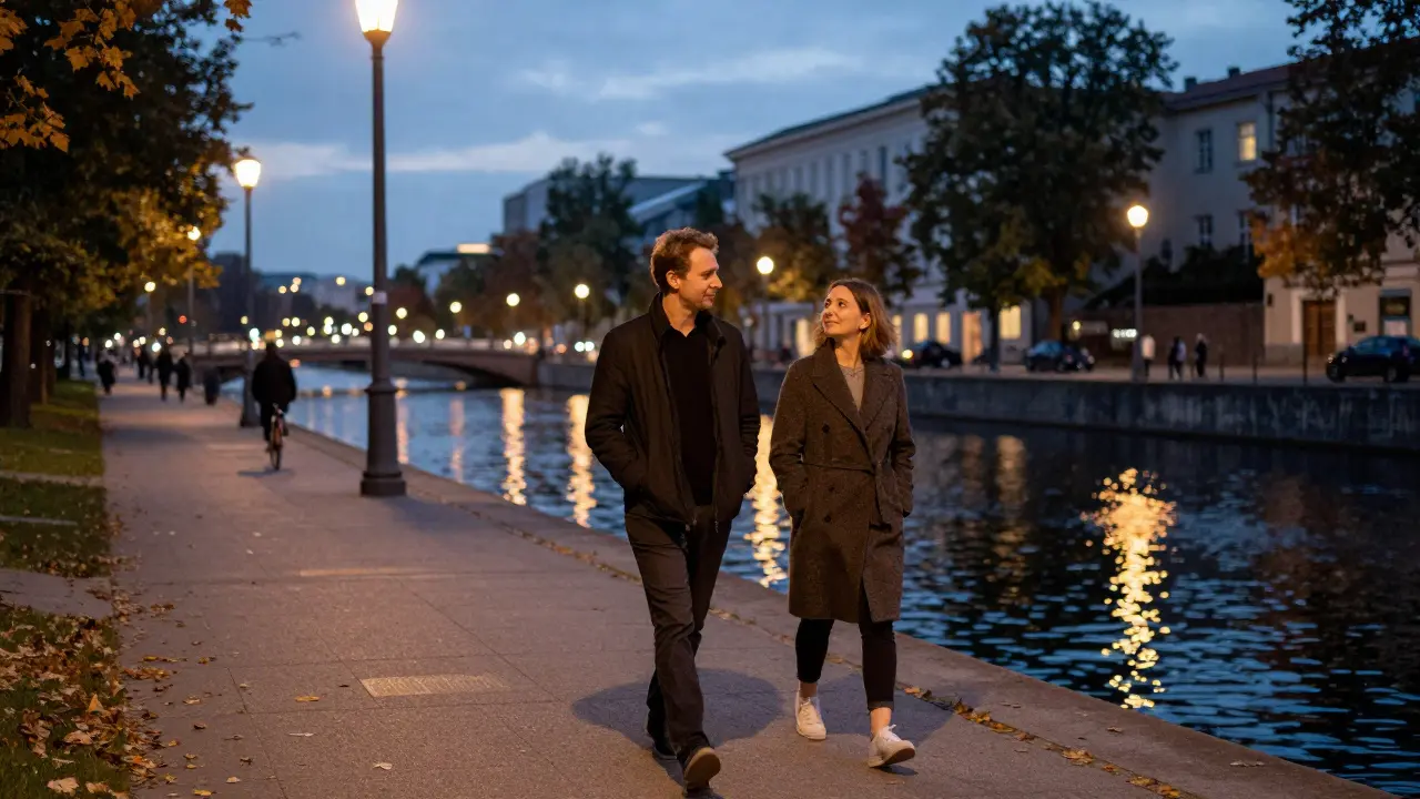 Couple walking peacefully along Berlin’s canal at dusk, autumn leaves, quiet companionship, no physical contact.